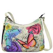 Anna by Anuschka style 8241, handpainted Cross Body Hobo. Floral Paradise painting in white color. Featuring two vertical zippered pocket at gusset, Fits E-Reader, Fits tablet, Fits Laptop.