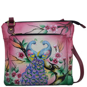 Anna by Anuschka style 8285, handpainted Multi Pocket Crossbody. Peacock Paradise painting in pink/peach color. Inside zippered wall pocket, open wall pocket, two multipurpose pockets, Fits E-Reader, Fits tablet.