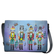 Anna by Anuschka style 8292, handpainted Multi Compartment Flap Crossbody. Nutcracker Party painting in blue color. Featuring flap with snap button entry to three open and one zippered compartment, Fits E-Reader, Hands-free.
