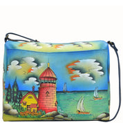 Anna by Anuschka style 8073, handpainted East West Bag. Lighthouse painting in blue color. Featuring full length pocket with magnetic closure, Fits tablet, Fits E-Reader, Fits phone.